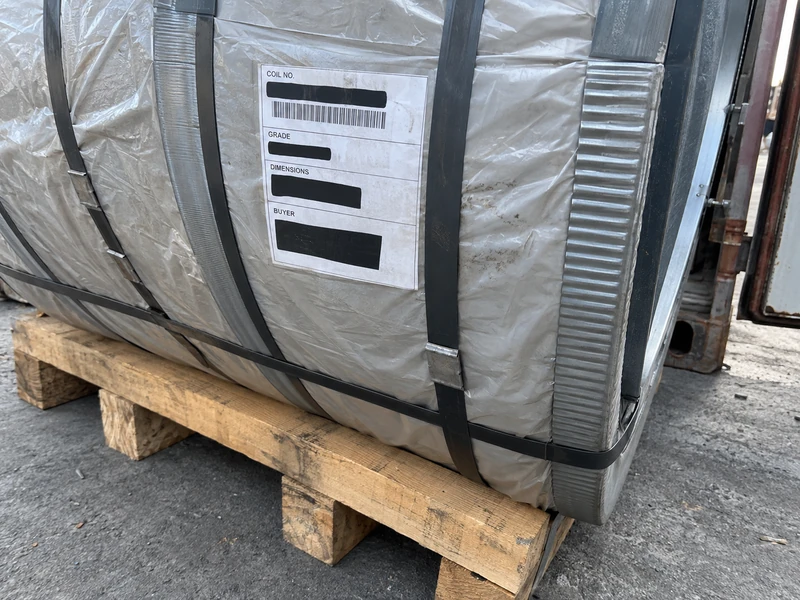 The label on a packed coil showing the coil number, the grade and the dimensions, identifying details masked.