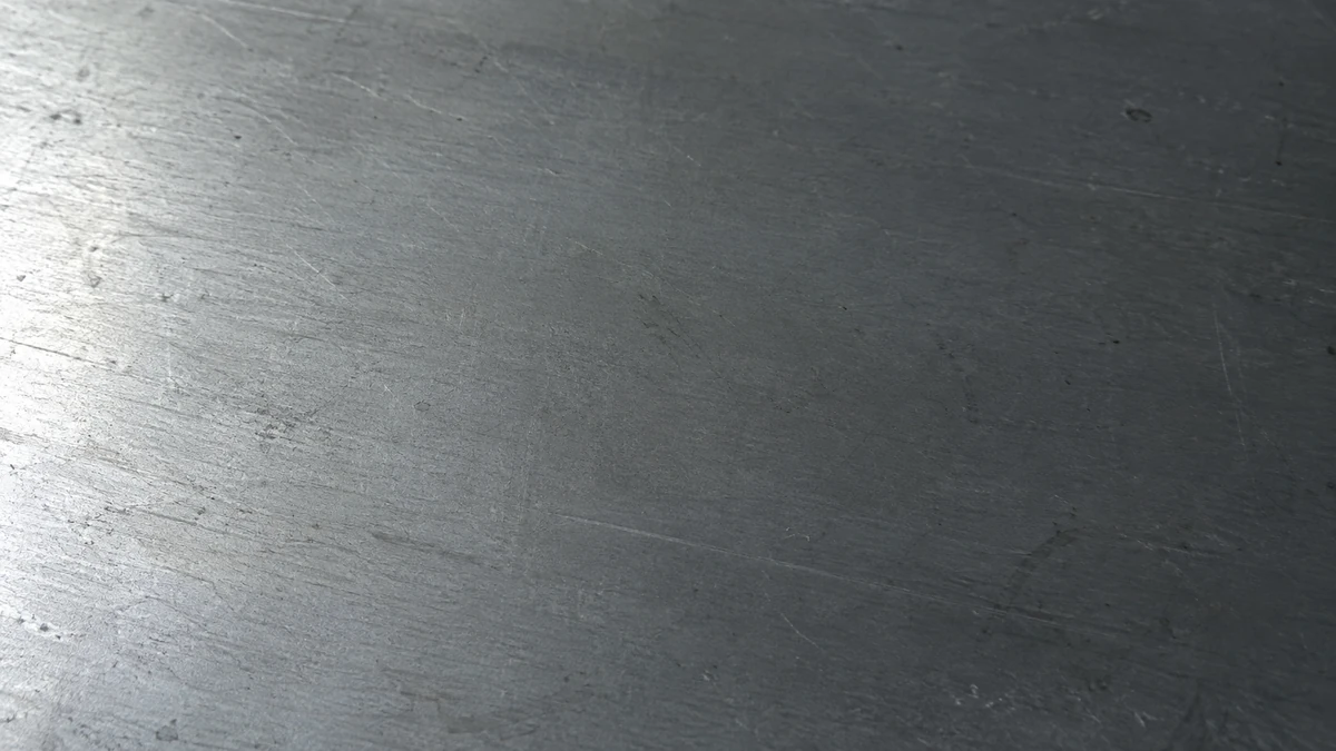 A matte cold rolled steel surface filling the frame, lit from one side.