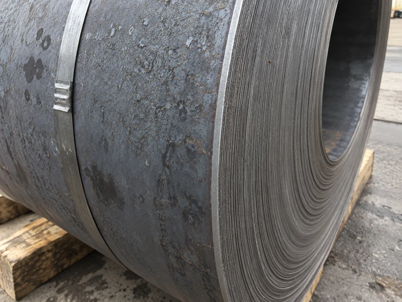 Close-up of a hot rolled coil edge, the scaled surface and the cut edge in the same frame.