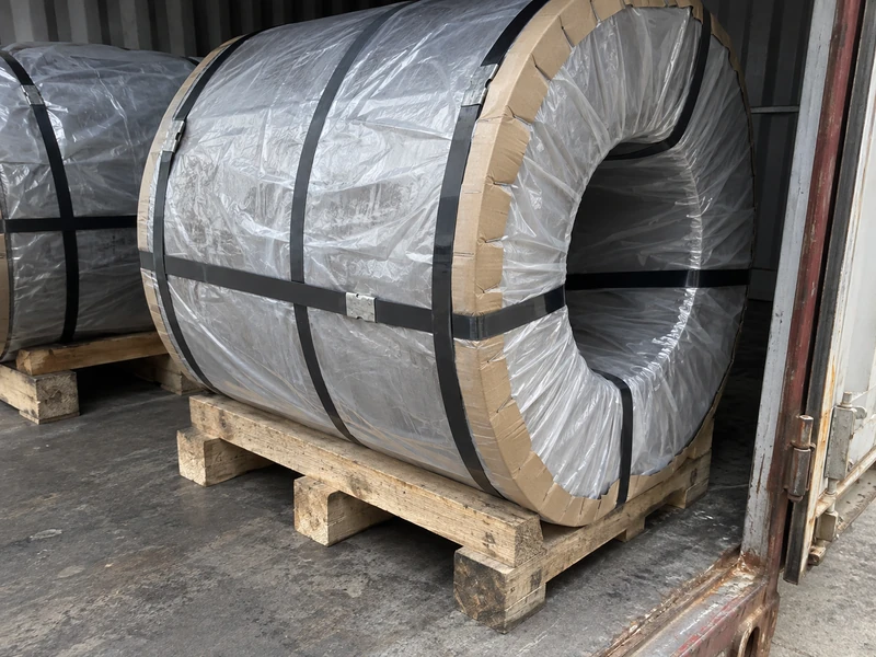 Uncoated Q355B coils packed on pallets in moisture-proof wrapping, strapped for the voyage.