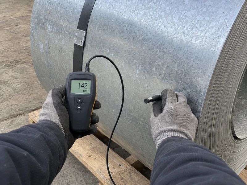 A coating mass check being made on a galvanized coil before shipment, the reading visible.