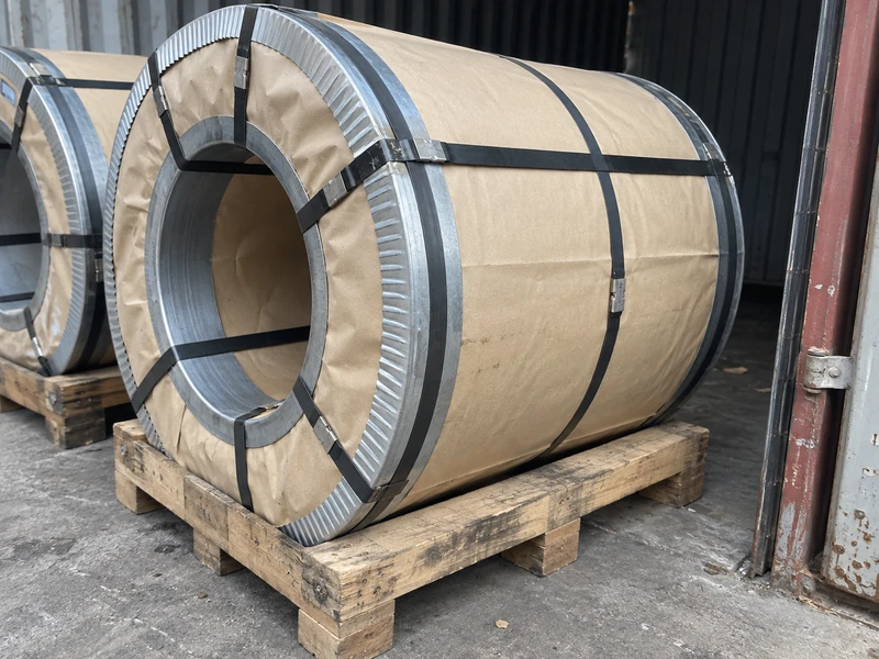 DX51D+Z coils packed with moisture-proof paper and steel edge protectors on pallets.