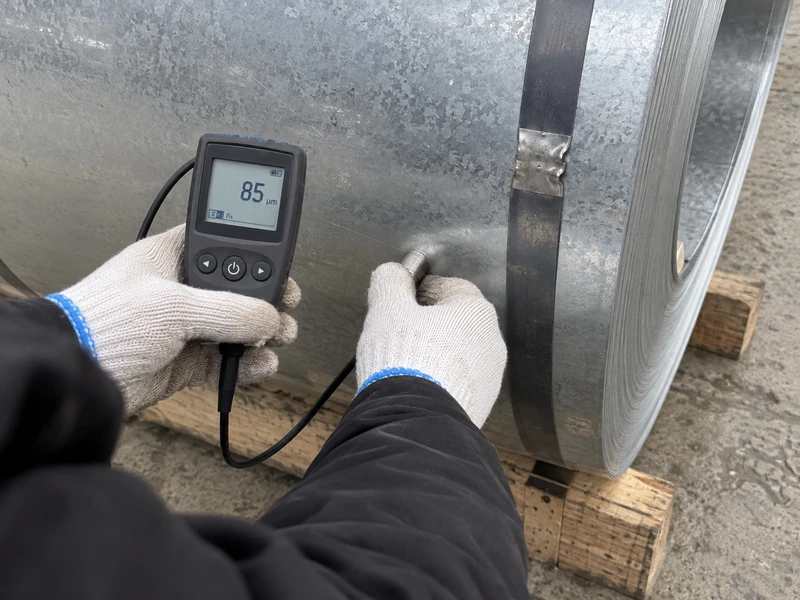 A coating check being made on an SGCC coil before shipment, the instrument reading visible.